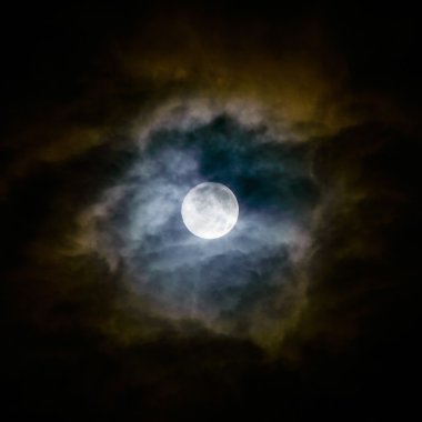 Dolunay ve üzerinde gece gökyüzünde bulutlar.