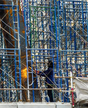 İnşaat alanında, iskele üzerinde çelik barlar kaynak inşaat işçisi.