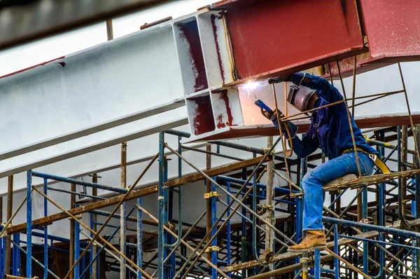 Um trabalhador de construção barras de aço de solda no andaime no canteiro de obras . — Fotografia de Stock