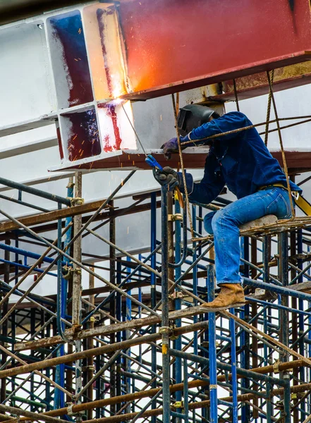 Un trabajador de la construcción soldando barras de acero en andamio en el sitio de construcción . —  Fotos de Stock