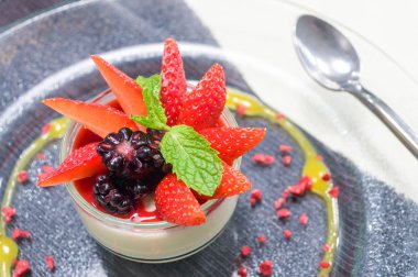 İtalyan tatlısı, çilek ve nane ile dekore edilmiş panna cotta.