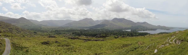 Paisagem irlandesa: colinas, oceano e céu com nuvens . — Fotografia de Stock