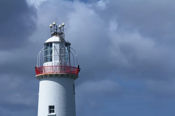 Маяк и небо на ирландском побережье — стоковое фото
