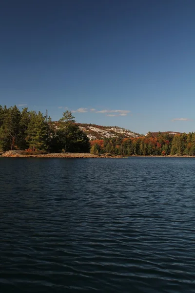 Lake, herfst bos en rotsachtige heuvels — Stockfoto