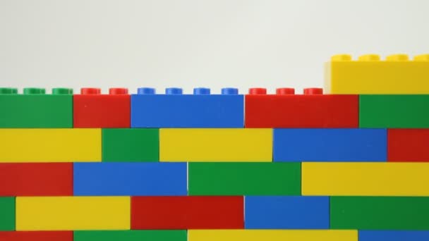 Mano añadiendo bloques a la pared lego — Vídeos de Stock