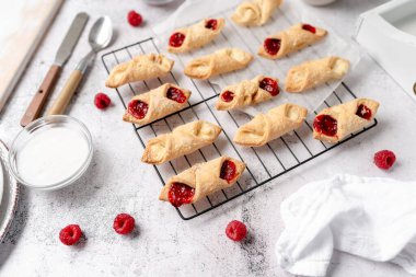 Krem peynirli ve ahududulu Kolacky. Reçelli ve kremalı hamur işi. Polonya Kolaczki kurabiyeleri, taze pişmiş.