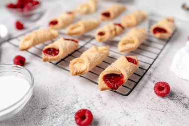 Krem peynirli ve ahududulu Kolacky. Reçelli ve kremalı hamur işi. Polonya Kolaczki kurabiyeleri, taze pişmiş.