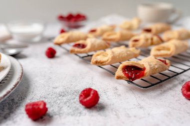 Krem peynirli ve ahududulu Kolacky. Reçelli ve kremalı hamur işi. Polonya Kolaczki kurabiyeleri, taze pişmiş.