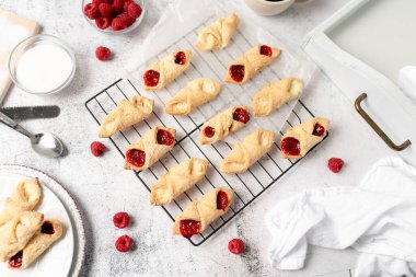 Krem peynirli ve ahududulu Kolacky. Reçelli ve kremalı hamur işi. Polonya Kolaczki kurabiyeleri, taze pişmiş.