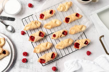 Krem peynirli ve ahududulu Kolacky. Reçelli ve kremalı hamur işi. Polonya Kolaczki kurabiyeleri, taze pişmiş.