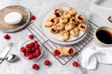 Krem peynirli ve ahududulu Kolacky. Reçelli ve kremalı hamur işi. Polonya Kolaczki kurabiyeleri, taze pişmiş.