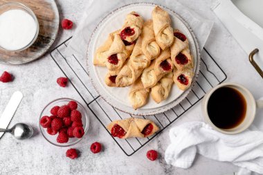 Krem peynirli ve ahududulu Kolacky. Reçelli ve kremalı hamur işi. Polonya Kolaczki kurabiyeleri, taze pişmiş.