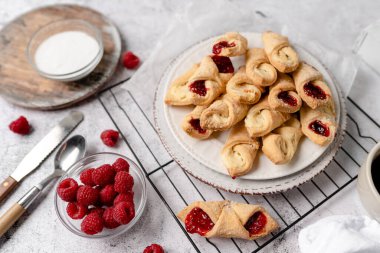 Krem peynirli ve ahududulu Kolacky. Reçelli ve kremalı hamur işi. Polonya Kolaczki kurabiyeleri, taze pişmiş.