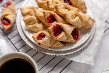Krem peynirli ve ahududulu Kolacky. Reçelli ve kremalı hamur işi. Polonya Kolaczki kurabiyeleri, taze pişmiş.