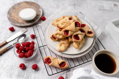 Krem peynirli ve ahududulu Kolacky. Reçelli ve kremalı hamur işi. Polonya Kolaczki kurabiyeleri, taze pişmiş.