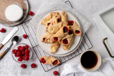 Krem peynirli ve ahududulu Kolacky. Reçelli ve kremalı hamur işi. Polonya Kolaczki kurabiyeleri, taze pişmiş.