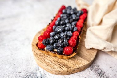 Fruit Tart full of Berries with chocolate and cream on cookie crust. European dissert.