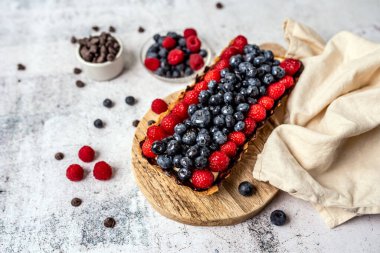 Fruit Tart full of Berries with chocolate and cream on cookie crust. European dissert.