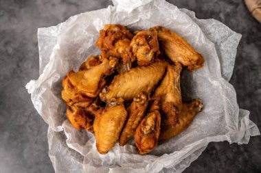 Chicken wings for dinner. Wings served in a basket with paper.