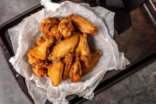 Chicken wings for dinner. Wings served in a basket with paper.