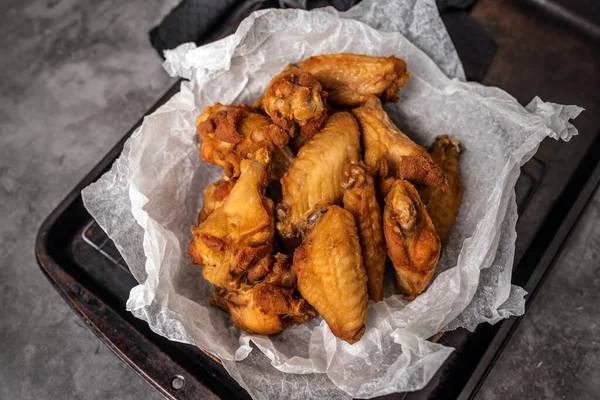 Chicken wings for dinner. Wings served in a basket with paper.