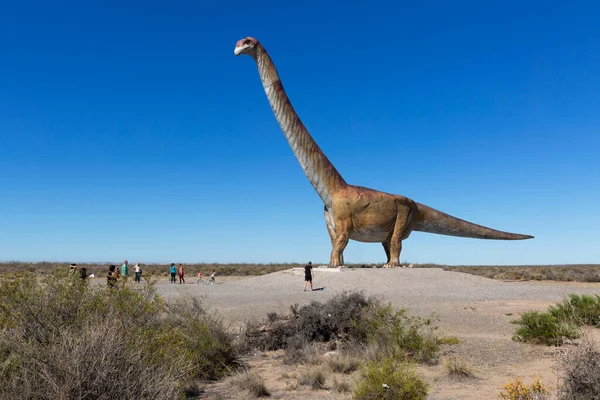 Otoyol kenarındaki dinozor. Otoyolun yakınında bir dinozor heykeli görülebilir. Yazıtın yanında dünyanın en büyük dinozoru Trelew 'dedir..