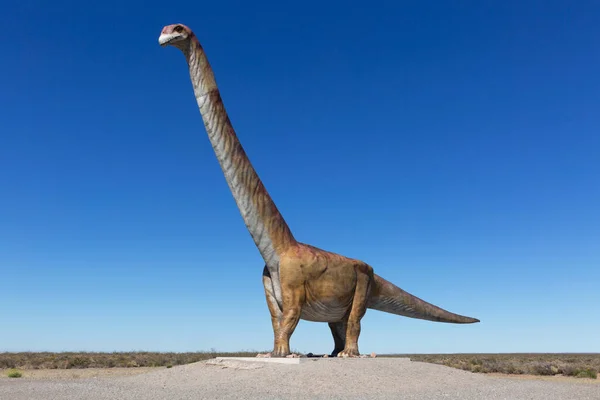 Otoyol kenarındaki dinozor. Otoyolun yakınında bir dinozor heykeli görülebilir. Yazıtın yanında dünyanın en büyük dinozoru Trelew 'dedir..