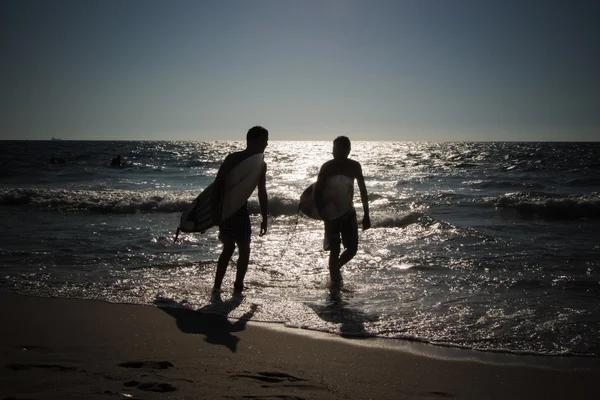 Sylwetki młodych surferów na morzu — Zdjęcie stockowe