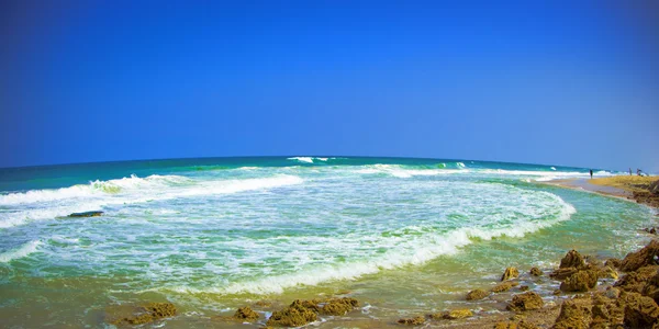 Paisaje marino con cielo despejado, olas y piedras — Foto de Stock