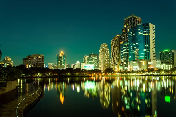 Centro de la ciudad por la noche con reflejo del horizonte, verde esmeralda — Foto de Stock