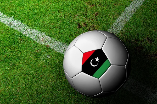 Libysche Flagge Muster eines Fußballs im grünen Gras — Stockfoto