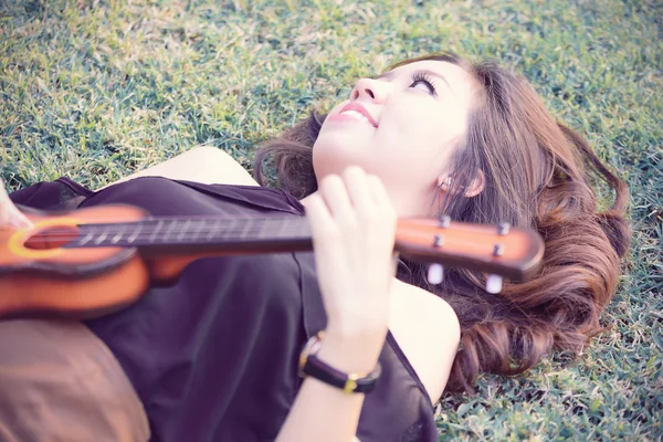 Asiatische Frauen spielen Ukulele im Park Vintage Ton — Stockfoto