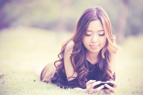 공원에서 휴대 전화를 얘기 하는 아시아 여성 — 스톡 사진