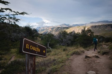 Los Glaciares Ulusal Parkı 'ndaki turist rotasında El Chalten' i işaret ediyor. Sırt çantalı bir turist Laguna Torre 'den El Chalten' e, And Dağları 'na, Patagonya' ya, Arjantin 'e yürüyüş parkurunda. Yol üzerindeki işaret direği