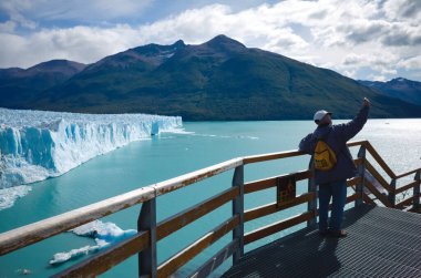 Los Glaciares Ulusal Parkı, Santa Cruz, Arjantin - Mart 2020: Yalnız turist Perito Moreno Buzulu ve Lago Argentino Gölü 'ne karşı selfie çekiyor. Erkek gezgin buzul bakış açısıyla fotoğraf çekiyor. 