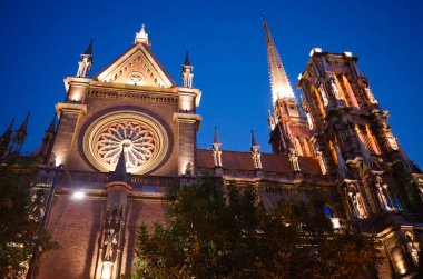 Iglesia del Sagrado Corazon de Jesus adlı gotik kilisenin yan görüntüsü, Arjantin 'in Cordoba şehrinde bulunan Iglesia de los Capuchinos olarak da bilinir. Katolik kilisesi geceleri arka planda aydınlanıyor.