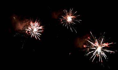 Siyah zemin üzerinde neşeli havai fişeklerin ve parlak parçacıkların dokusu