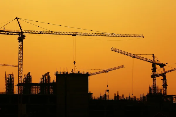 Guindastes de construção industrial e silhuetas de construção — Fotografia de Stock