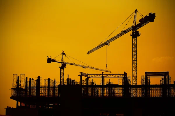 Grues de construction industrielle et silhouettes de construction — Photo