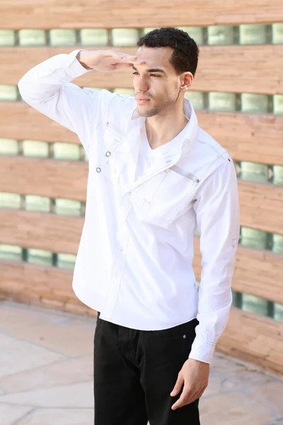Mladý pohledný muž v bílé košili hledá — Stock fotografie