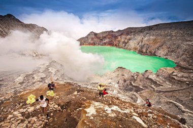Tanımlanamayan madenci kawah Ijen'de yanardağ krateri gelen ham kükürt hasat
