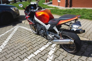 Modern turuncu motosiklet kaldırımda hiç insan yok.