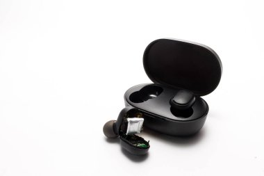 Çalışmayan kablosuz kulaklık ve açık bir kutu.