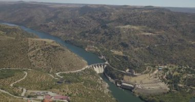 Penedo Durao 'nun hava aracı görüntüleri, tipik Uluslararası Douro Park manzarası, Douro nehri üzerindeki baraj ve arka plan olarak İspanya' nın kuzeyindeki dağlık bölgeler....
