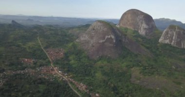 Tropikal bir arazinin hava aracı görüntüleri, orman ve dağlarla kumbira orman rezervleri, küçük köy ve Conda, Sumbe, Angola 'daki devasa jeolojik kaya elementleri....