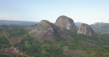 Tropikal bir arazinin hava aracı görüntüleri, orman ve dağlarla kumbira orman rezervleri, küçük köy ve Conda, Sumbe, Angola 'daki devasa jeolojik kaya elementleri....