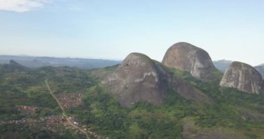 Tropikal bir arazinin hava aracı görüntüleri, orman ve dağlarla kumbira orman rezervleri, küçük köy ve Conda, Sumbe, Angola 'daki devasa jeolojik kaya elementleri....