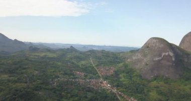 Tropikal bir arazinin hava aracı görüntüleri, orman ve dağlarla kumbira orman rezervleri, küçük köy ve Conda, Sumbe, Angola 'daki devasa jeolojik kaya elementleri....
