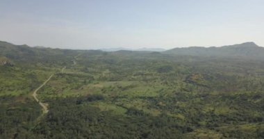 Tropikal bir arazinin hava aracı görüntüleri, orman ve dağlarla kumbira orman rezervleri, küçük köy ve Conda, Sumbe, Angola 'daki devasa jeolojik kaya elementleri....