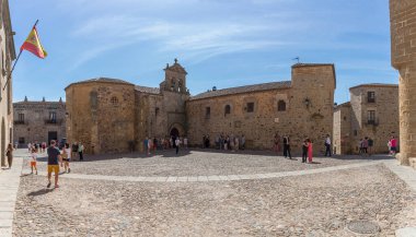 İspanya - 09: 12 2021: San Pablo Manastırı 'ndaki ortaçağ binasına bakın, Plaza de las Veletas' ta, turistler sokakta, şehir merkezinde ortaçağ caddesinde, Caceres şehrinde geziniyorlar.